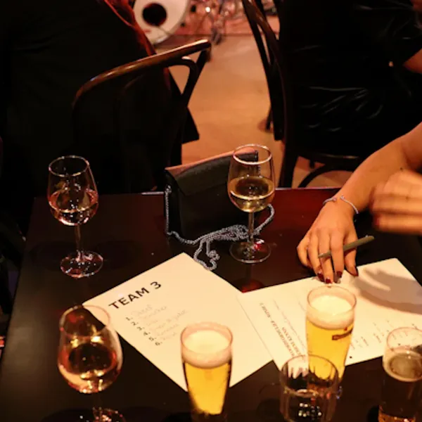 Teams overleggen aan tafel tijdens de muziekquiz